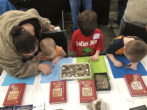 Kids looking over numismatic information